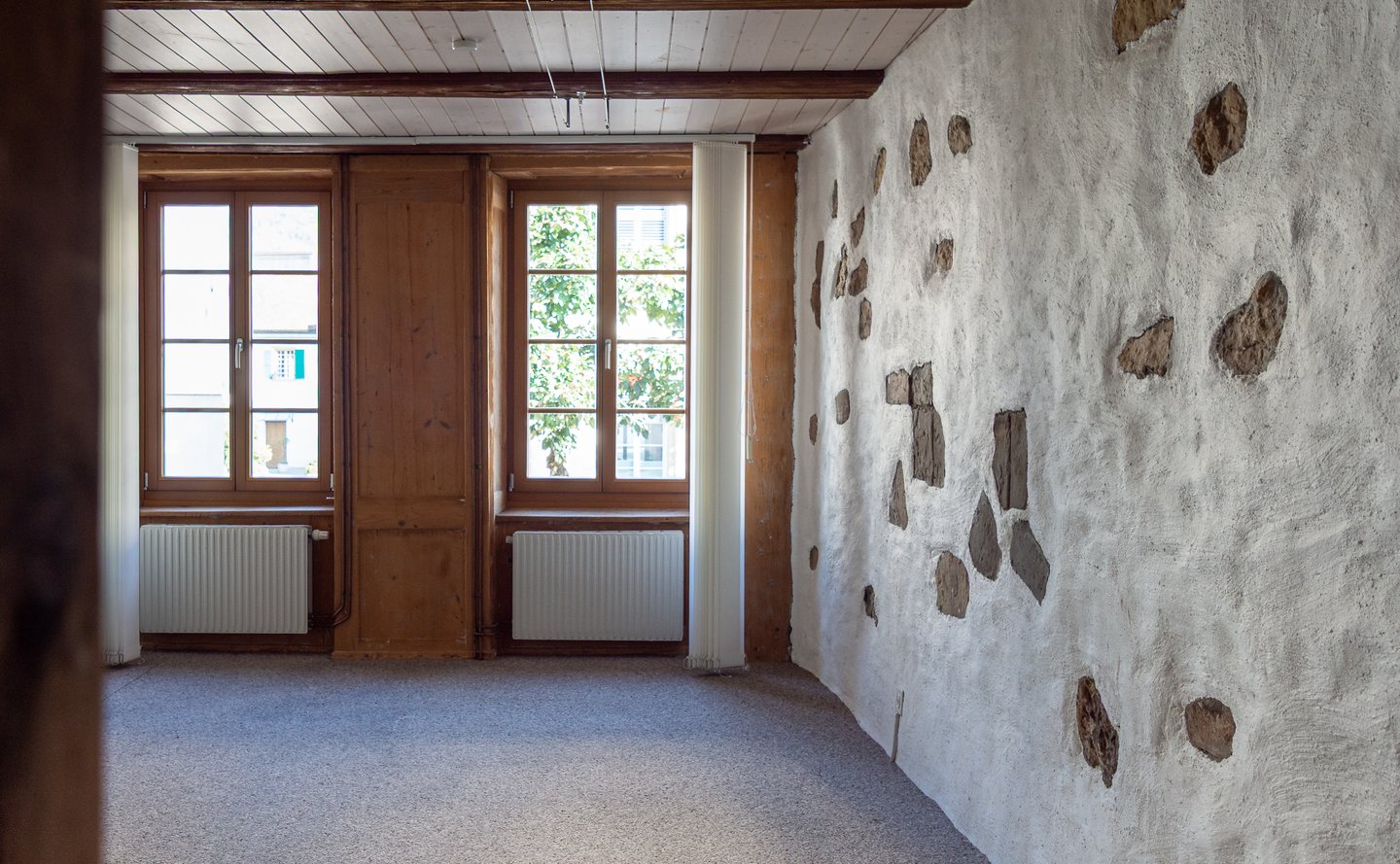 Zimmer mit Lehmwänden und Sichtsteinen